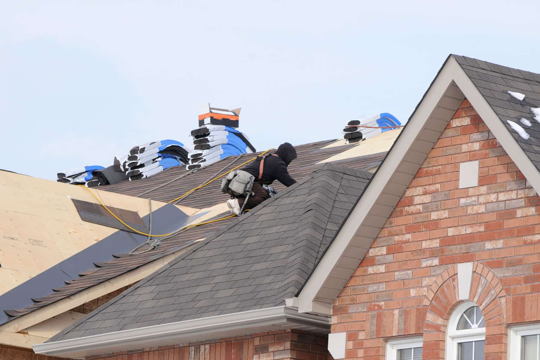 Roofing professional inspecting and repairing shingles on a home in Fate, Texas